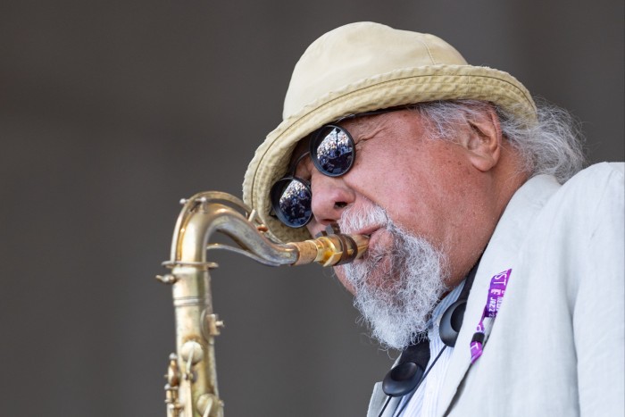Un homme à la barbe grise souffle dans un saxophone